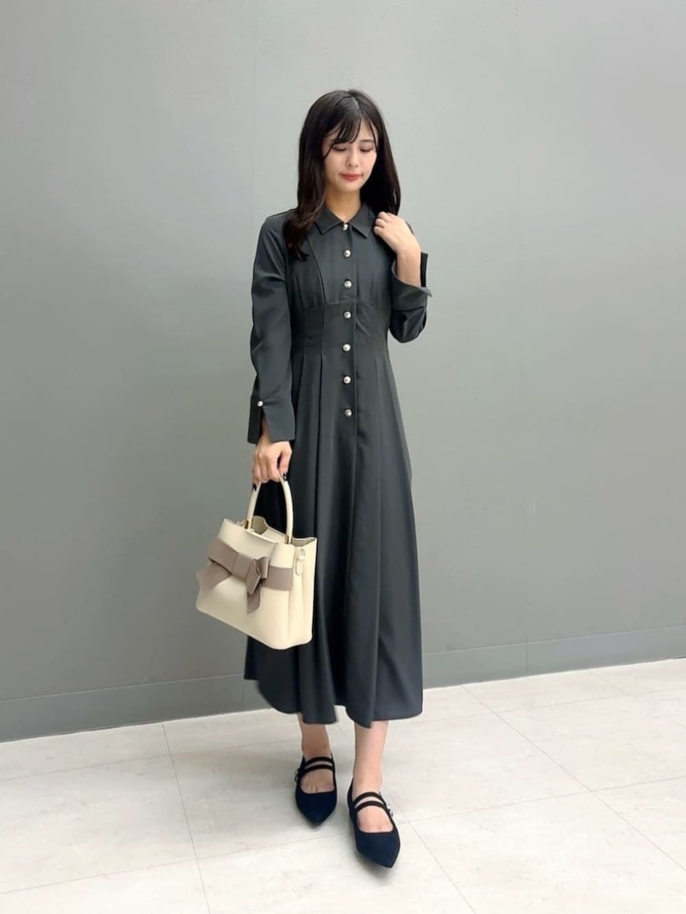 ブラック系のパンプス、ベージュ系のショルダーバッグ、グレー系のワンピースを着用したレディースの秋コーディネートの2枚目の写真