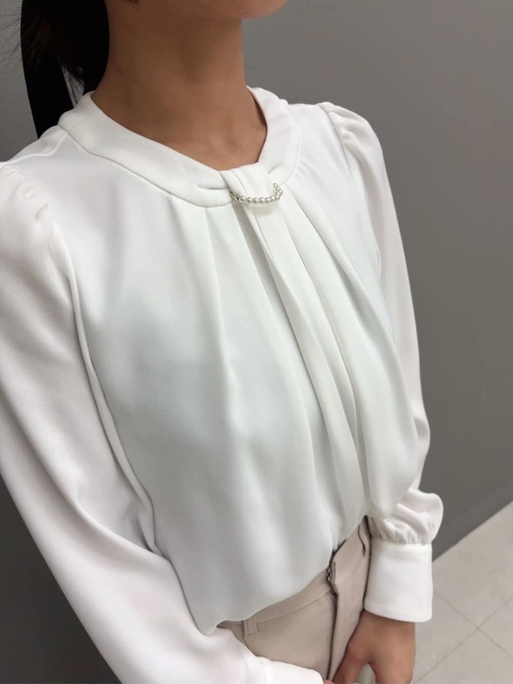 ホワイト系のショルダーバッグ、ホワイト系のシャツ/ブラウス、ベージュ系のその他パンツを着用したレディースの冬コーディネートの3枚目の写真