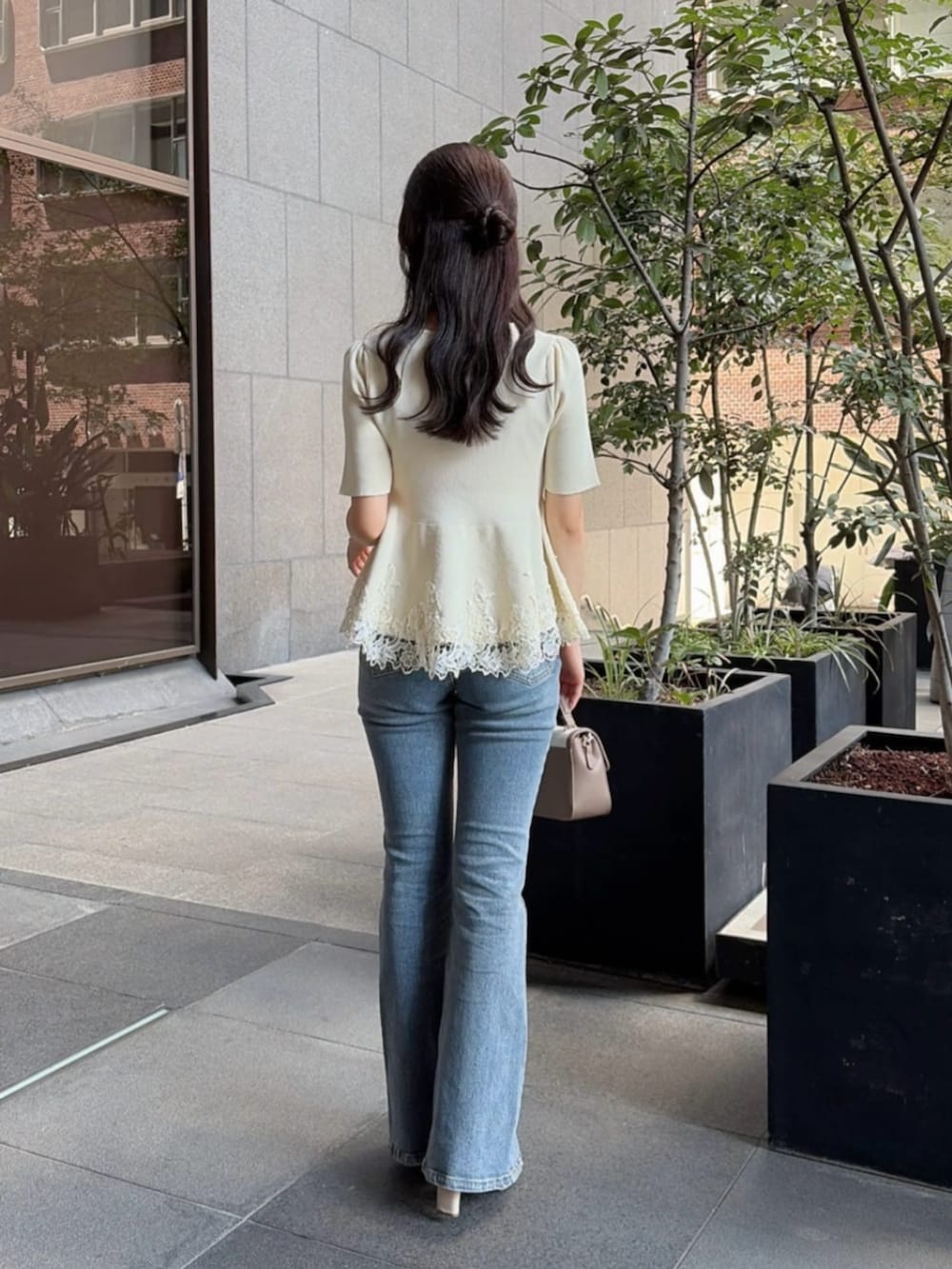 ベージュ系のパンプス、グレー系のショルダーバッグ、ホワイト系のニット/セーターを着用したレディースの夏コーディネートの2枚目の写真