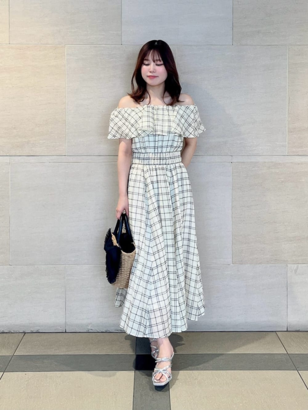 シルバー系のパンプス、ブラック系のショルダーバッグ、ホワイト系のワンピースを着用したレディースの夏コーディネートの2枚目の写真