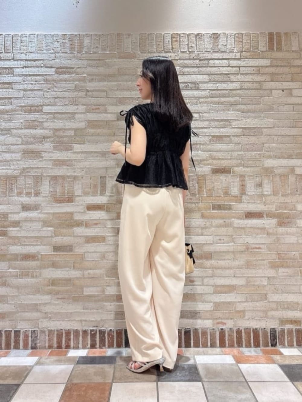 シルバー系のパンプス、ブラック系のシャツ/ブラウス、ホワイト系のその他パンツを着用したレディースの夏コーディネートの2枚目の写真