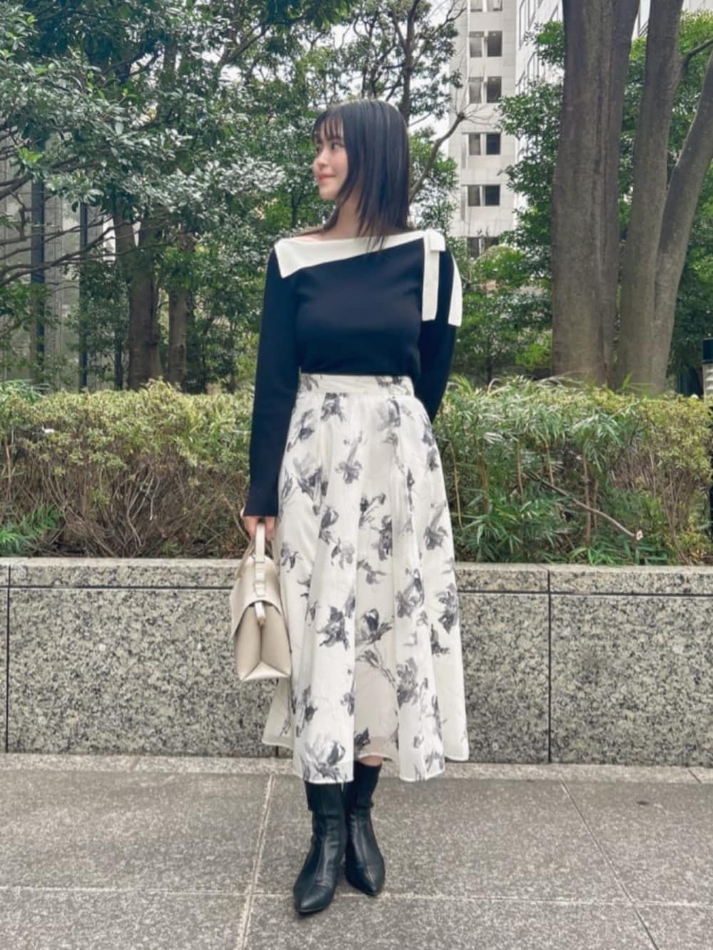 ブラック系のニット/セーター、グレー系のスカートを着用したレディースの冬コーディネートの2枚目の写真