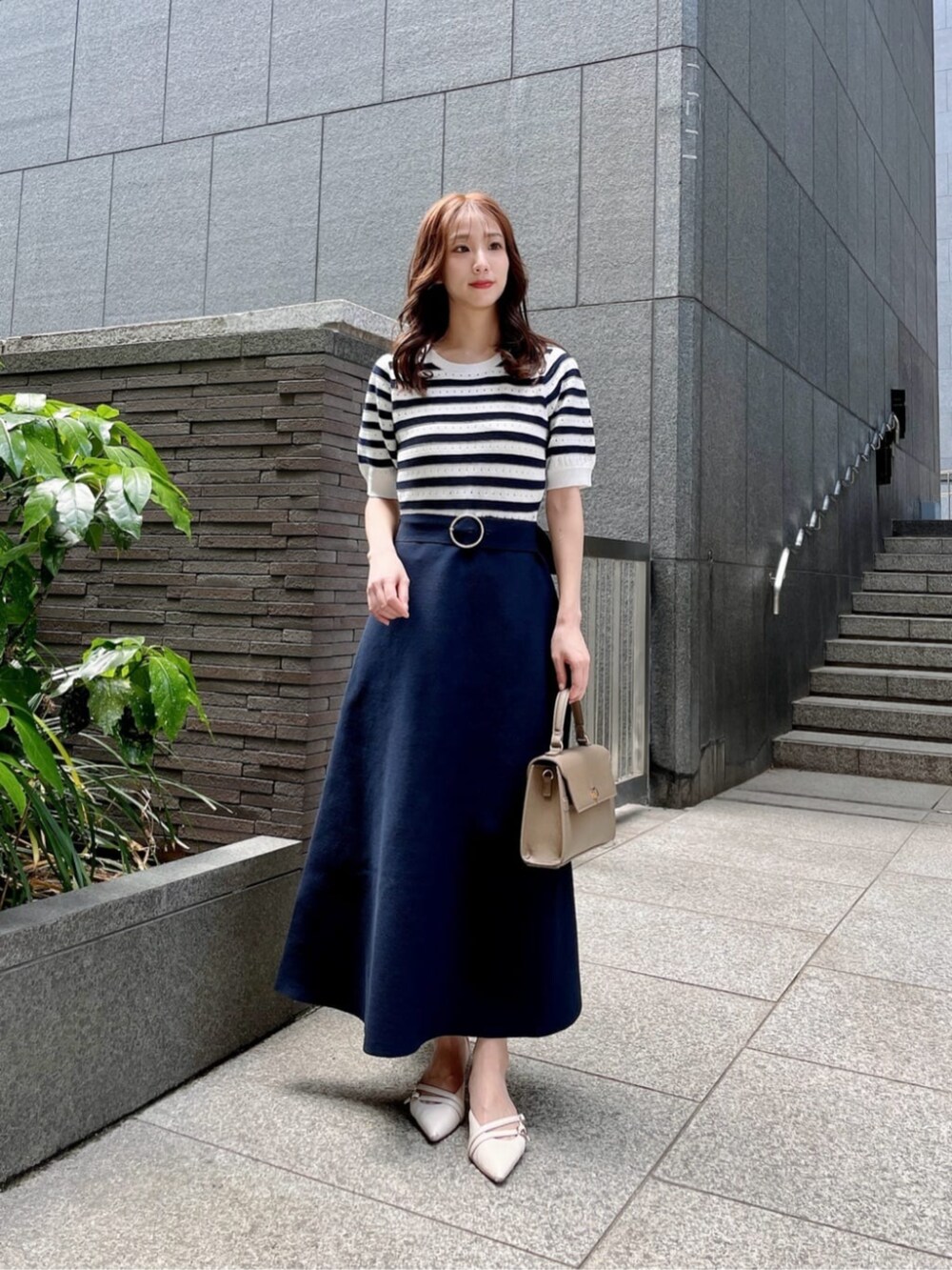 ブルー系のワンピース、ブラウン系のショルダーバッグを着用したレディースの春コーディネートの2枚目の写真