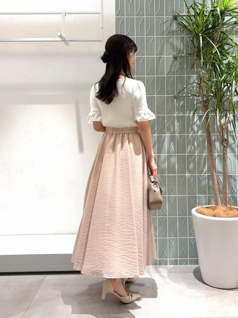 ベージュ系のパンプス、グレー系のショルダーバッグ、ホワイト系のニット/セーターを着用したレディースの夏コーディネートの3枚目の写真