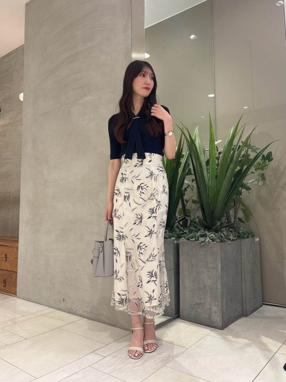 ホワイト系のスカート、ブルー系のニット/セーター、グレー系のショルダーバッグを着用したレディースの夏コーディネートの3枚目の写真