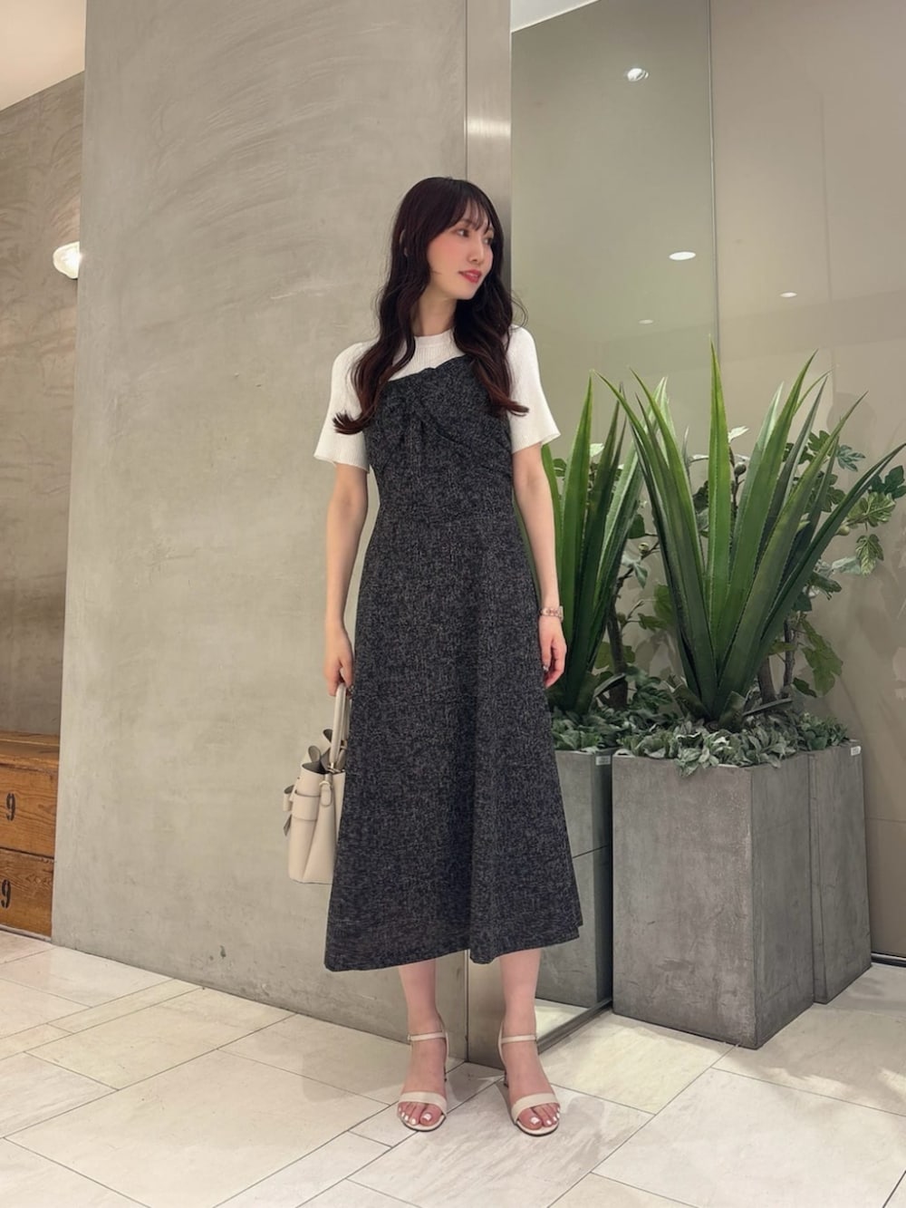 ホワイト系のショルダーバッグ、ブラック系のワンピースを着用したレディースの春コーディネートの2枚目の写真