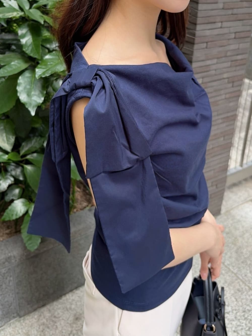 ブラック系のパンプス、ブラック系のショルダーバッグ、ブルー系のTシャツ/カットソーを着用したレディースの夏コーディネートの4枚目の写真