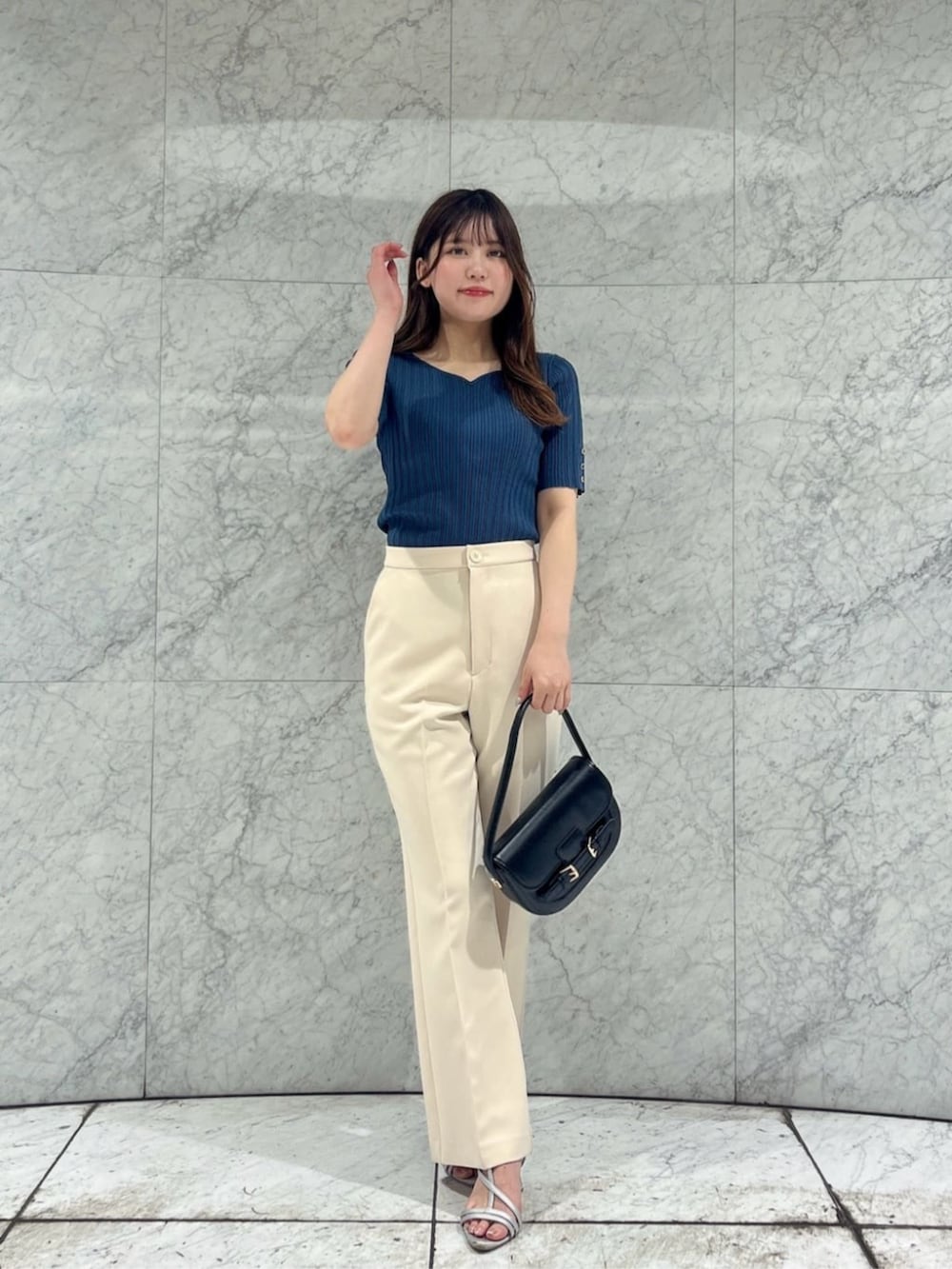 シルバー系のパンプス、ブラック系のショルダーバッグ、グリーン系のニット/セーターを着用したレディースの夏コーディネートの2枚目の写真