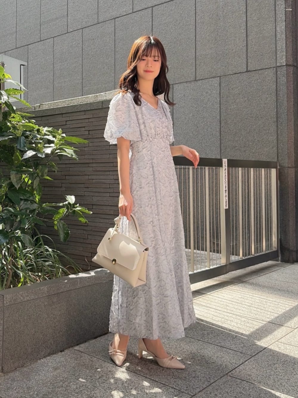 ベージュ系のパンプス、ブルー系のワンピースを着用したレディースの春コーディネートの2枚目の写真