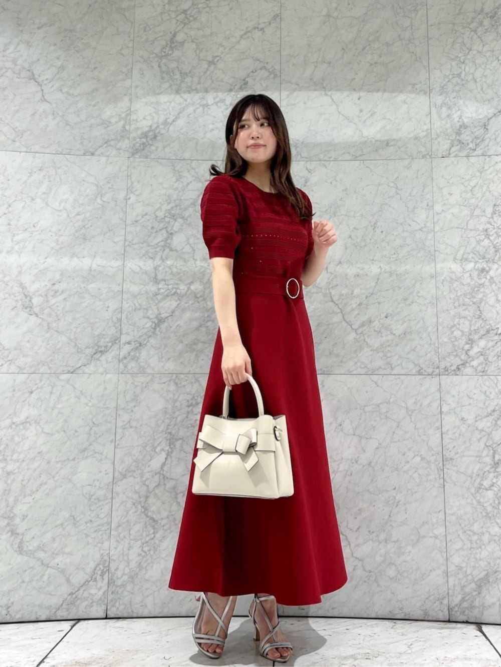 シルバー系のパンプス、レッド系のワンピース、ホワイト系のショルダーバッグを着用したレディースの春コーディネートの3枚目の写真