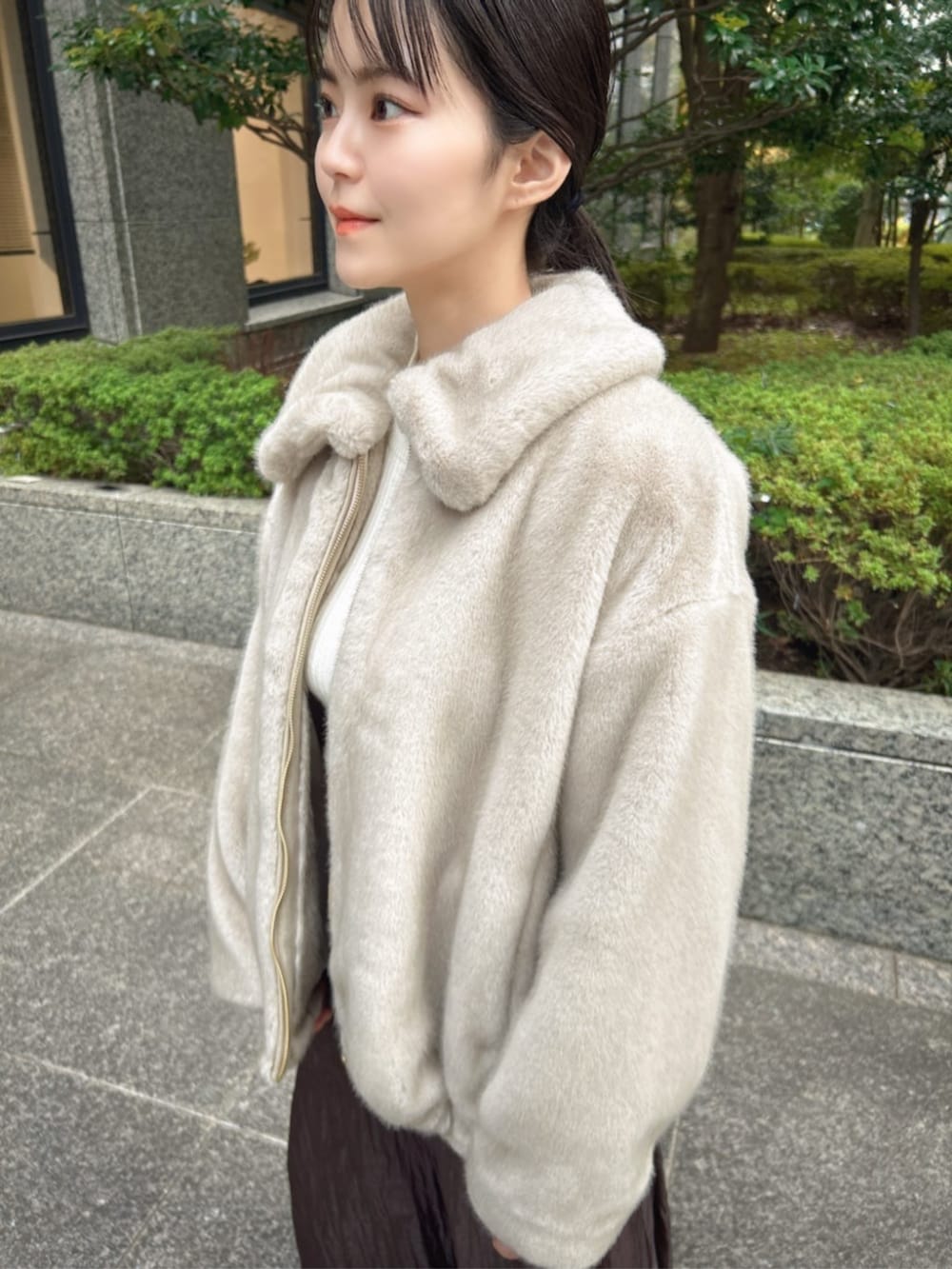 ブラウン系のブーツ、ブラウン系のスカート、グレー系のブルゾンを着用したレディースの冬コーディネートの2枚目の写真