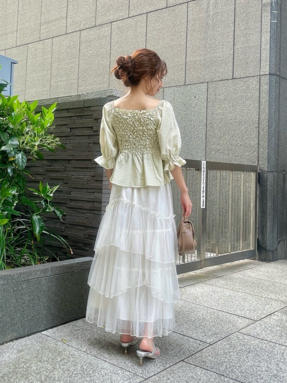 シルバー系のパンプス、グリーン系のシャツ/ブラウス、ホワイト系のスカートを着用したレディースの春コーディネートの3枚目の写真