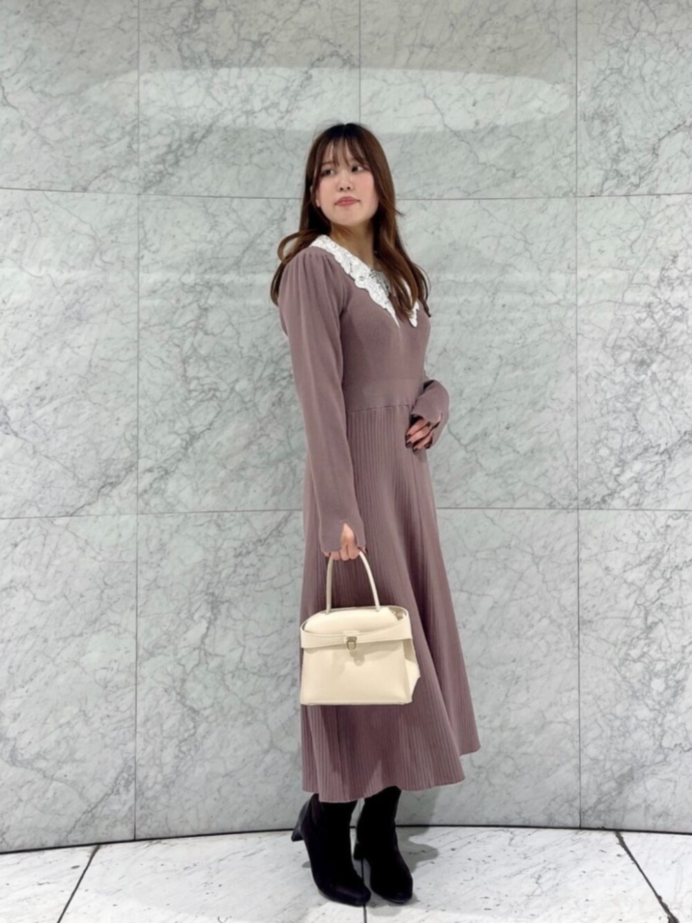 ホワイト系のトートバッグ、ブラウン系のワンピースを着用したレディースの冬コーディネートの3枚目の写真