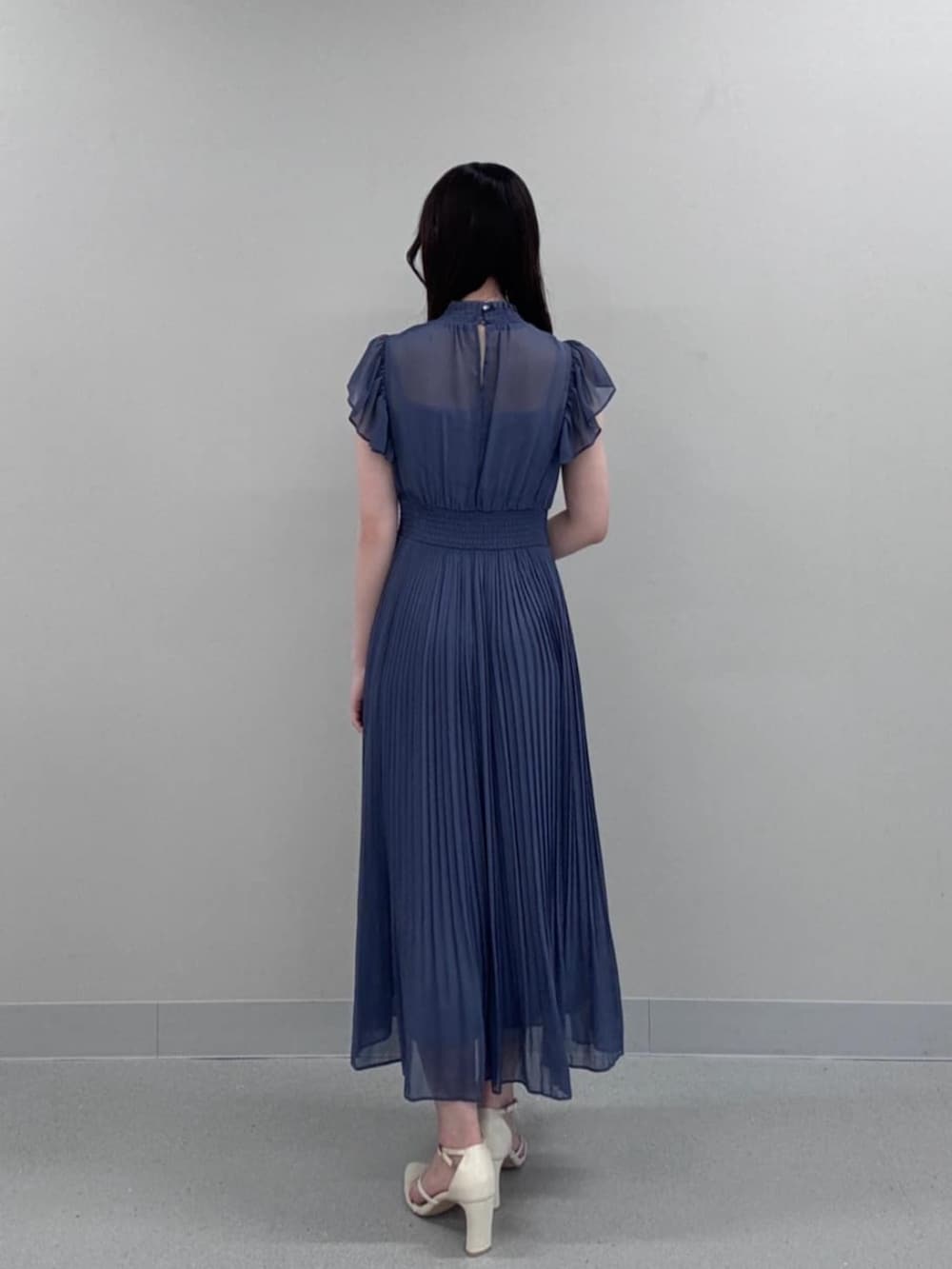 ホワイト系のパンプス、ブルー系のワンピースを着用したレディースの秋コーディネートの3枚目の写真