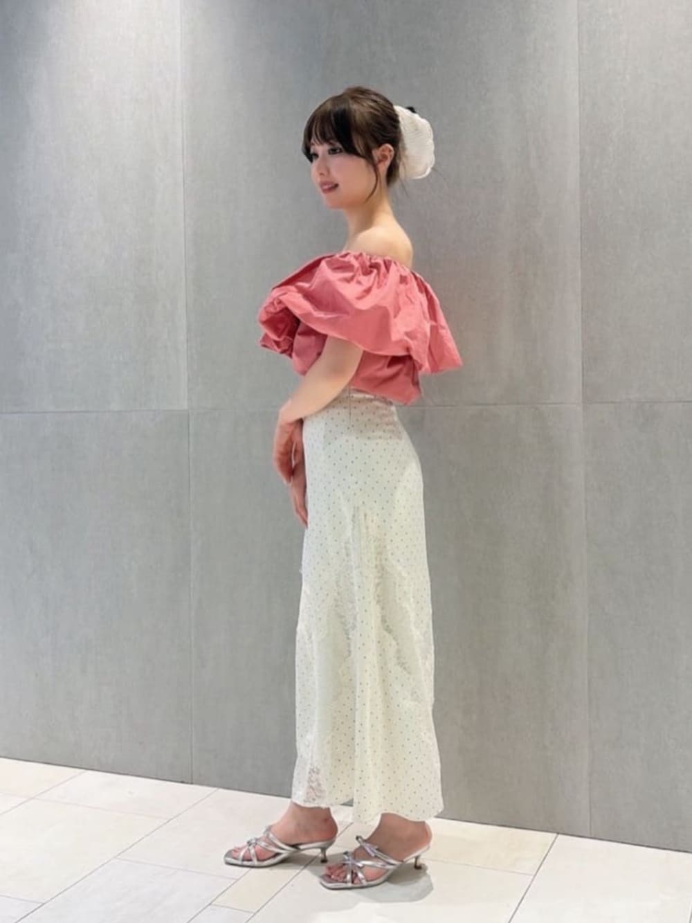 シルバー系のパンプス、ホワイト系のスカート、ピンク系のシャツ/ブラウスを着用したレディースの夏コーディネートの2枚目の写真
