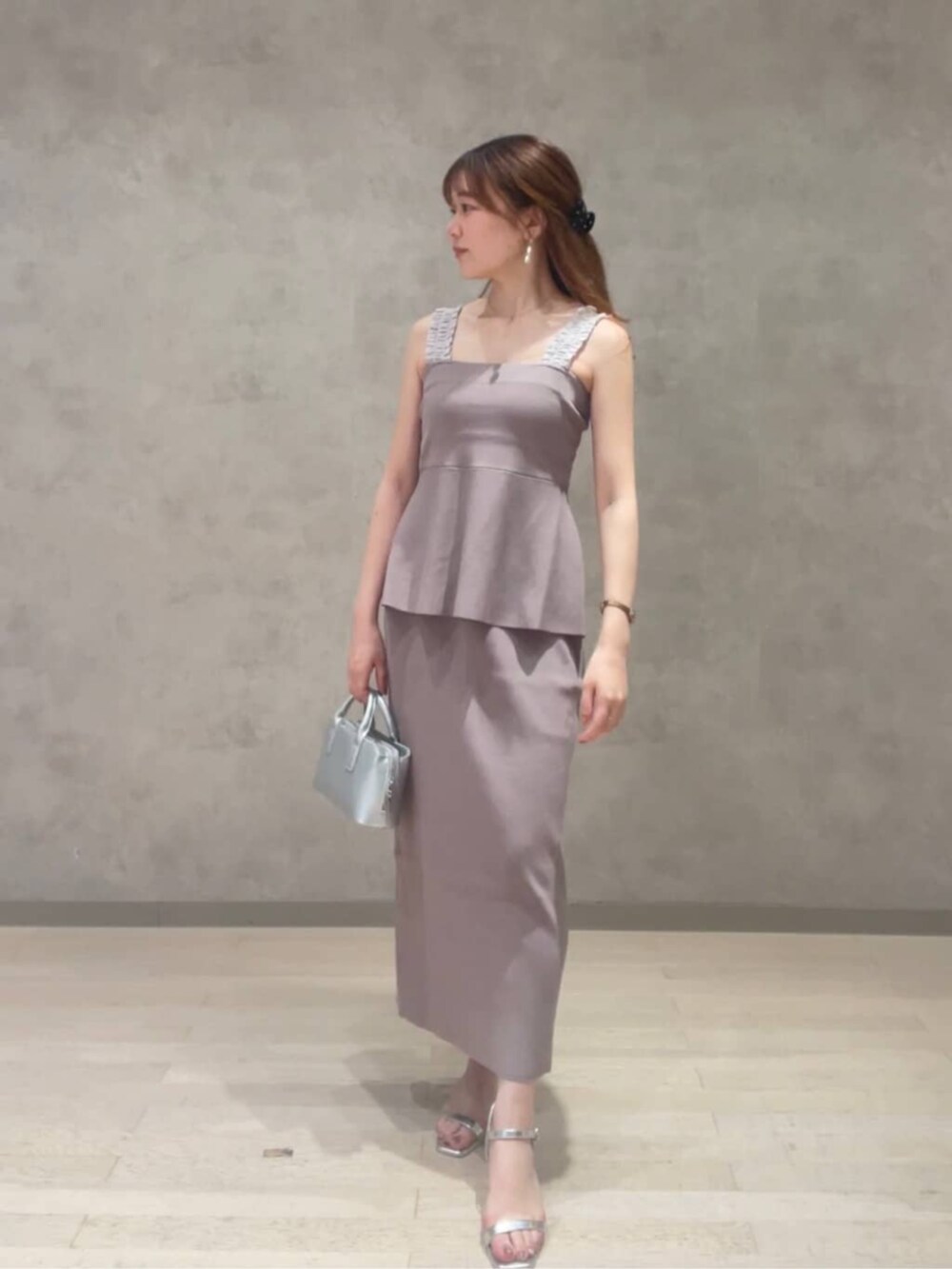 シルバー系のトートバッグ、ホワイト系のシャツ/ブラウス、グレー系のワンピースを着用したレディースの夏コーディネートの2枚目の写真