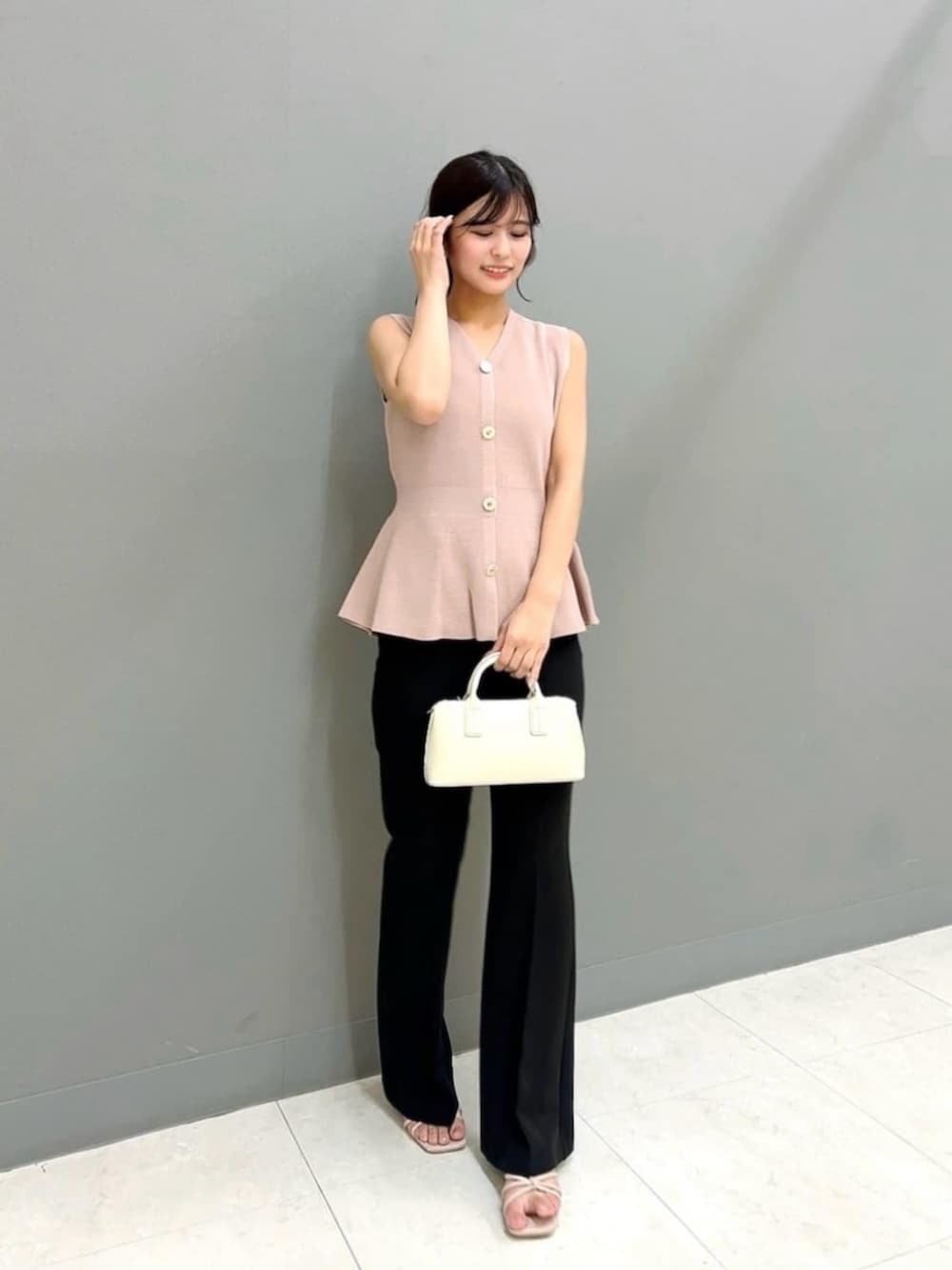 ホワイト系のトートバッグ、ピンク系のニット/セーター、ブラック系のその他パンツを着用したレディースの夏コーディネートの3枚目の写真