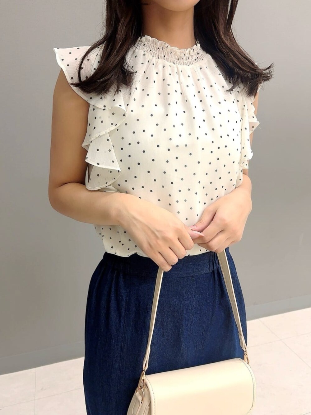 ホワイト系のショルダーバッグ、シルバー系のパンプス、ホワイト系のシャツ/ブラウスを着用したレディースの夏コーディネートの3枚目の写真