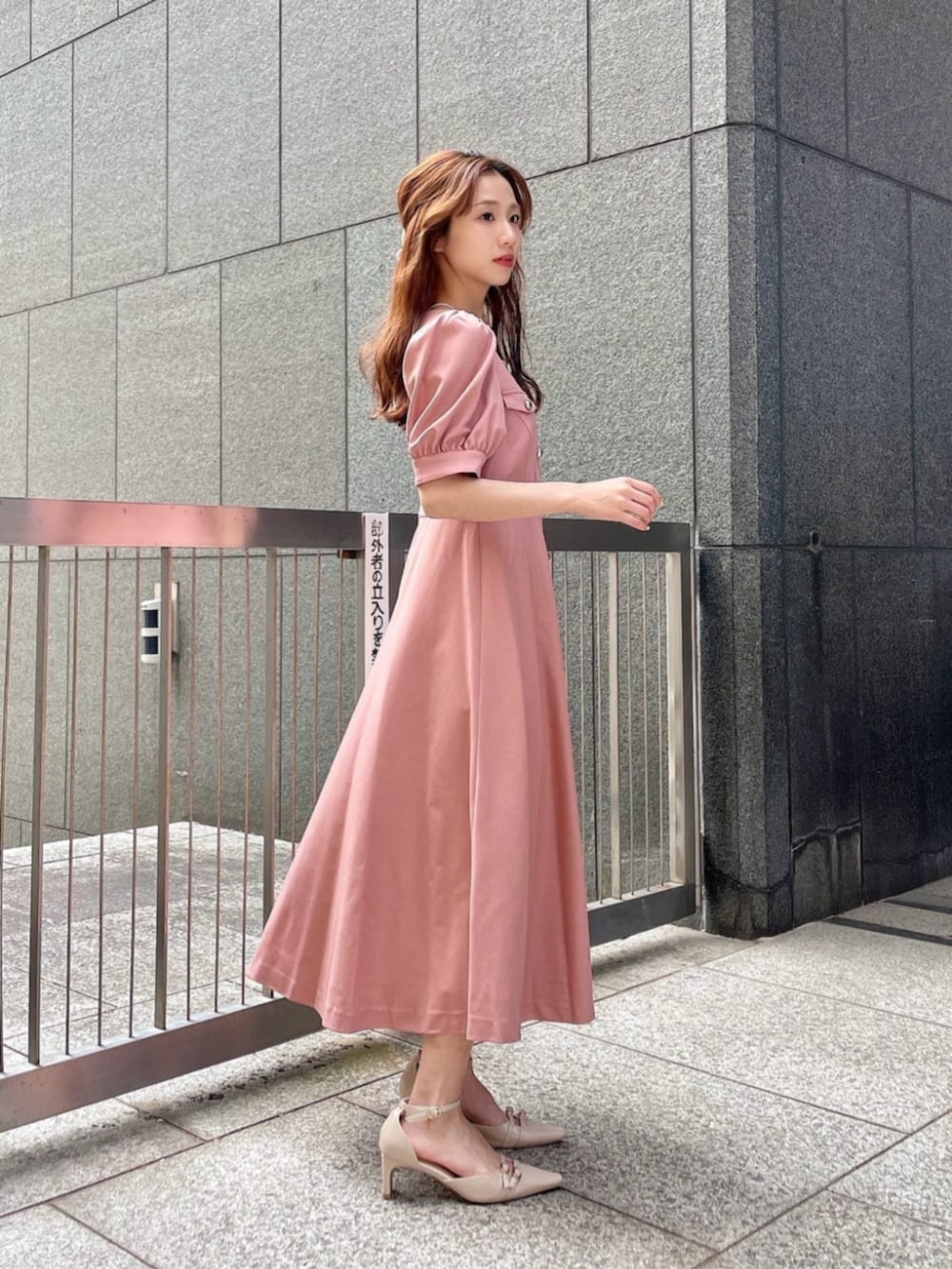 ホワイト系のショルダーバッグ、ベージュ系のパンプス、ピンク系のワンピースを着用したレディースの春コーディネートの2枚目の写真
