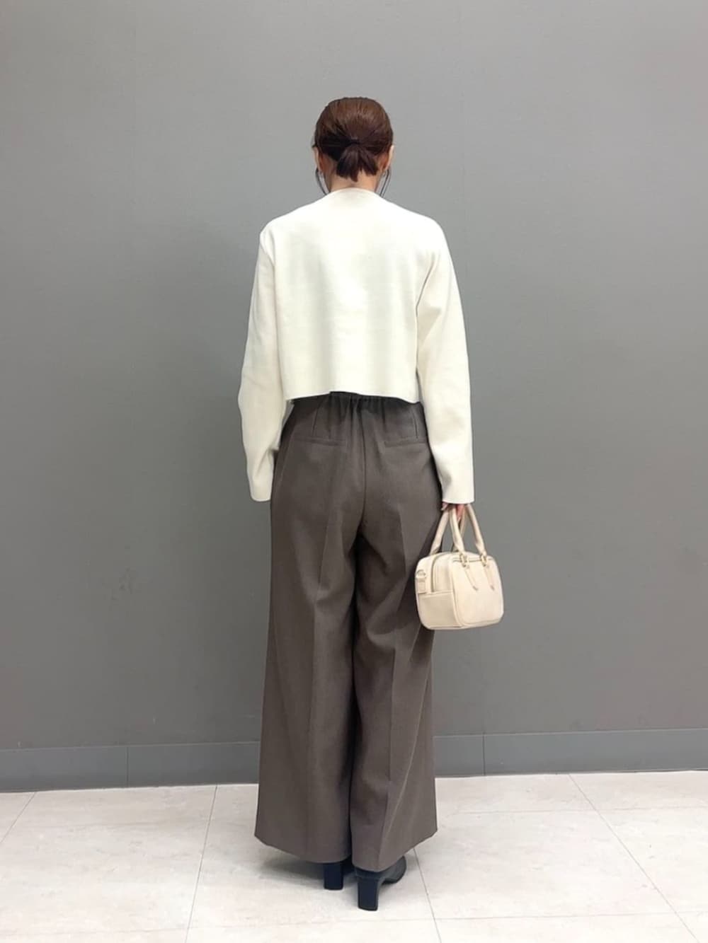 ホワイト系のボストンバッグ、ホワイト系のカーディガン/ボレロ、ブラウン系のその他パンツを着用したレディースの秋コーディネートの4枚目の写真