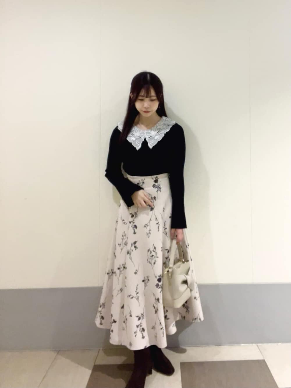 ブラック系のニット/セーター、ベージュ系のスカートを着用したレディースの秋コーディネートの3枚目の写真