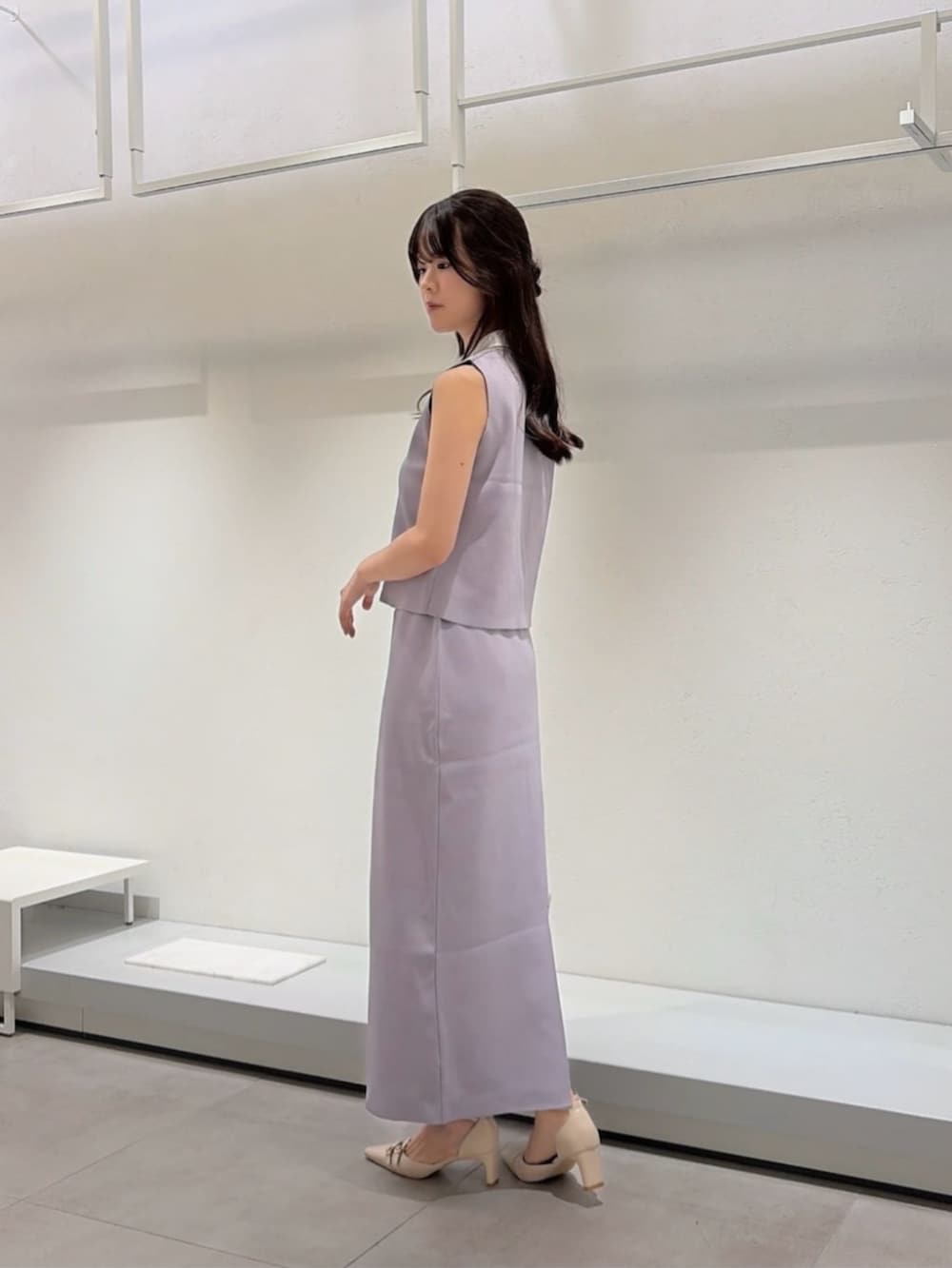 ベージュ系のパンプス、ブルー系のショルダーバッグ、グレー系のワンピースを着用したレディースの夏コーディネートの3枚目の写真