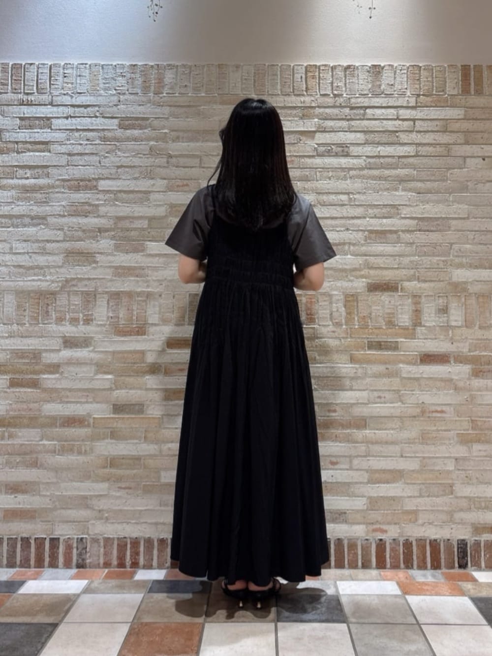 ブラック系のショルダーバッグ、ブラック系のパンプス、グレー系のTシャツ/カットソーを着用したレディースの夏コーディネートの3枚目の写真