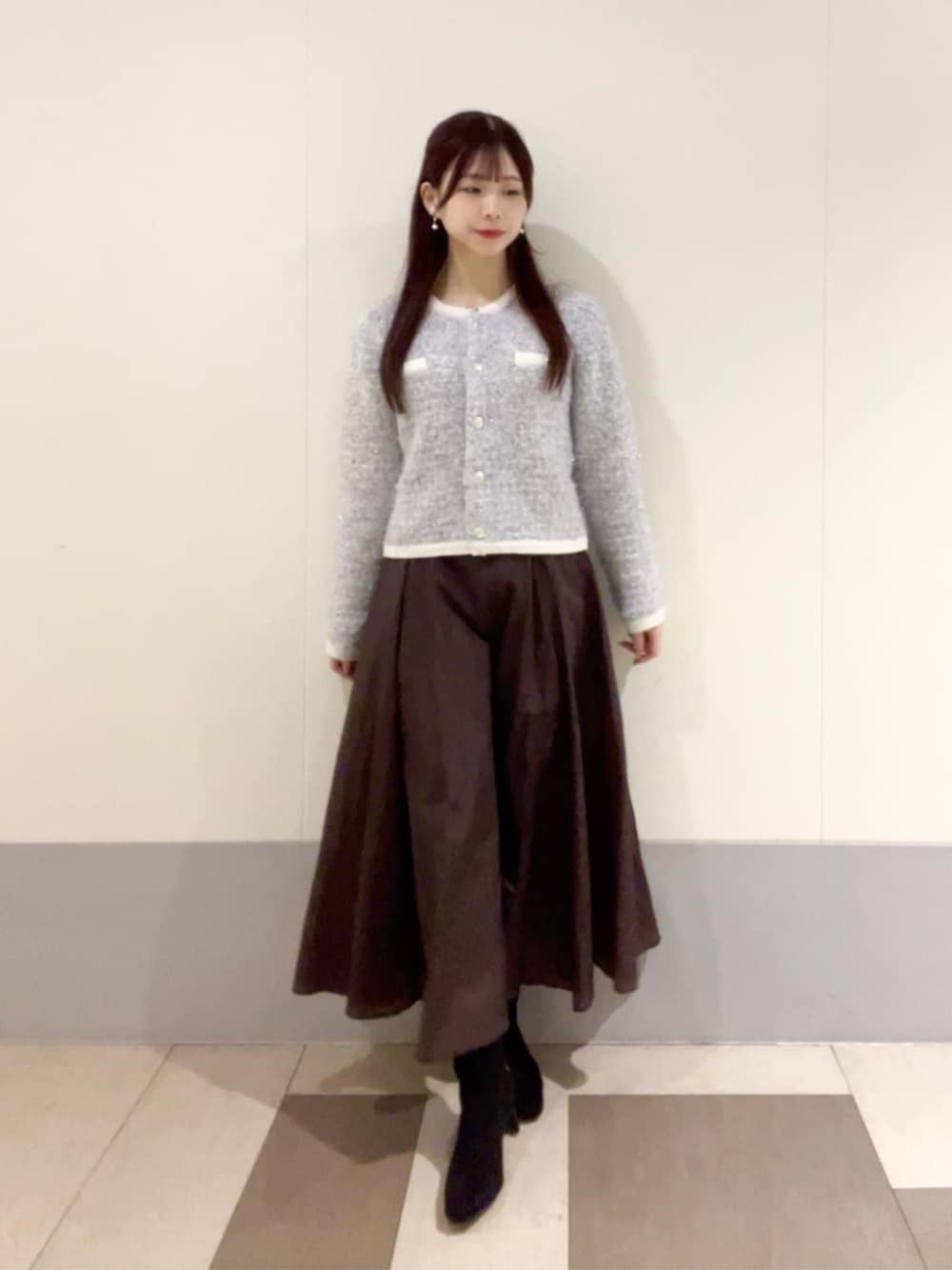 ブルー系のカーディガン/ボレロ、ブラウン系のスカートを着用したレディースの冬コーディネートの2枚目の写真