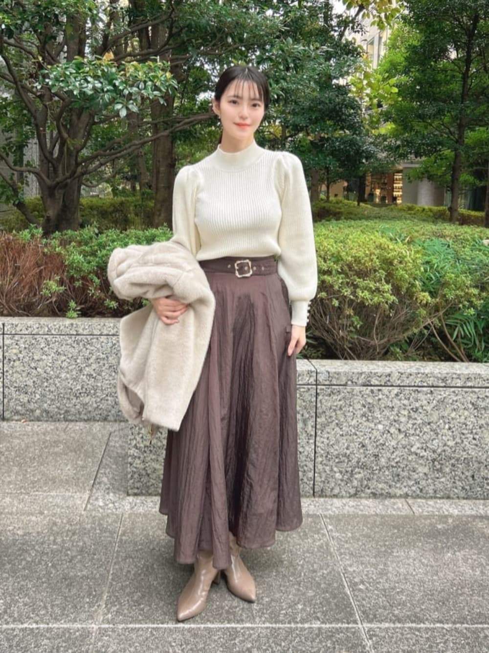 ブラウン系のブーツ、ブラウン系のスカート、グレー系のブルゾンを着用したレディースの冬コーディネートの3枚目の写真