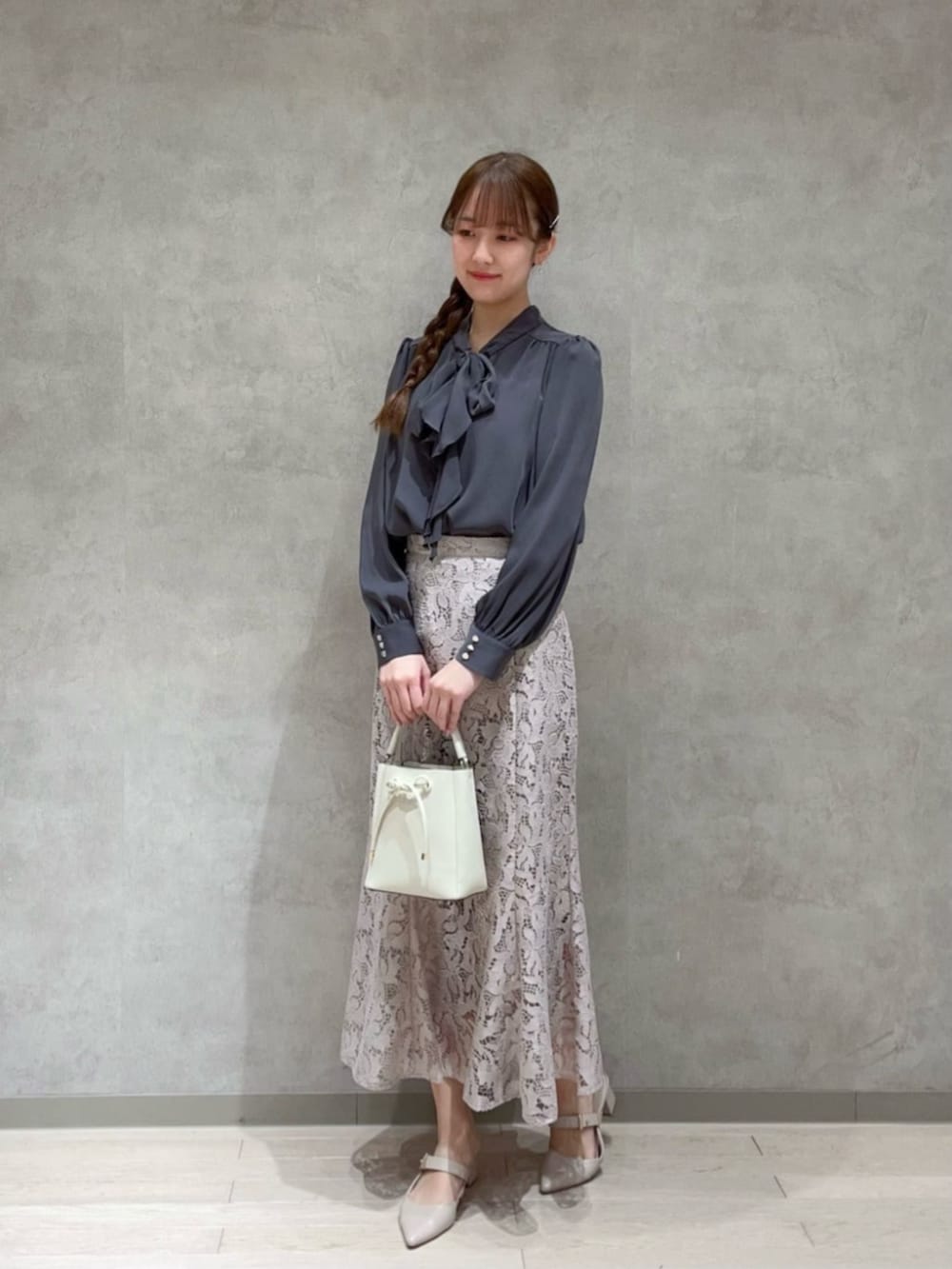 グレー系のシャツ/ブラウス、ベージュ系のスカートを着用したレディースの春コーディネートの2枚目の写真