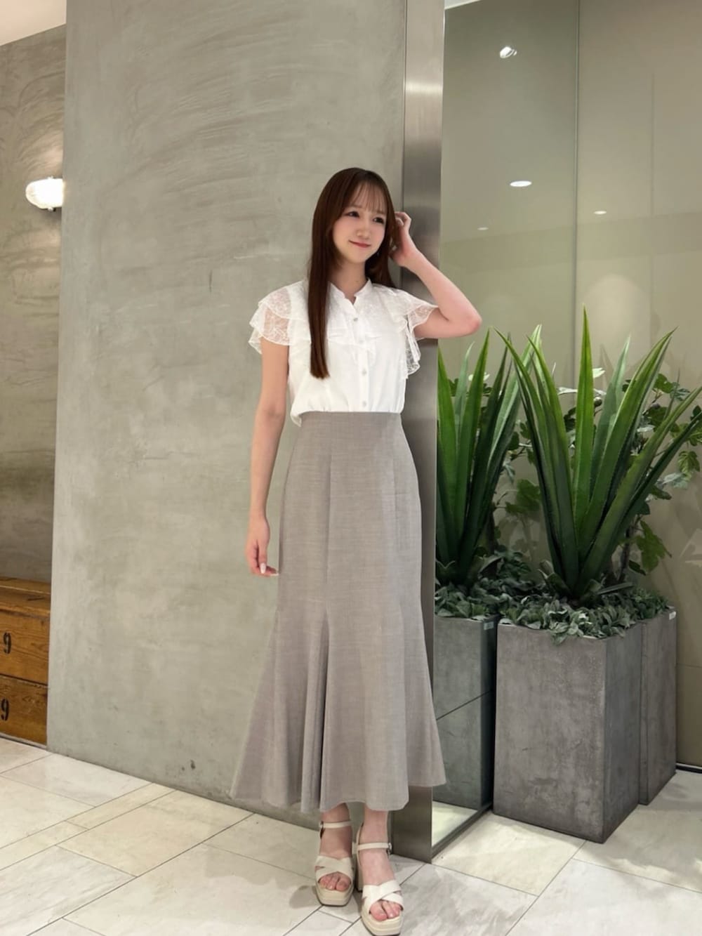 ブラウン系のスカート、ホワイト系のシャツ/ブラウスを着用したレディースの夏コーディネートの2枚目の写真