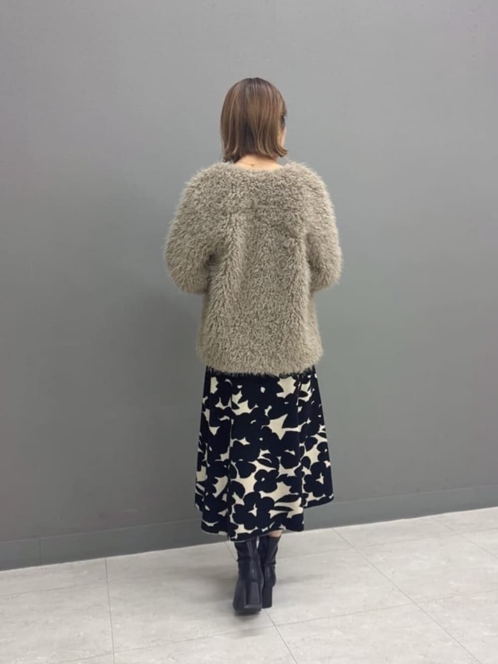 ブラウン系のブルゾン、ブラック系のワンピースを着用したレディースの冬コーディネートの3枚目の写真