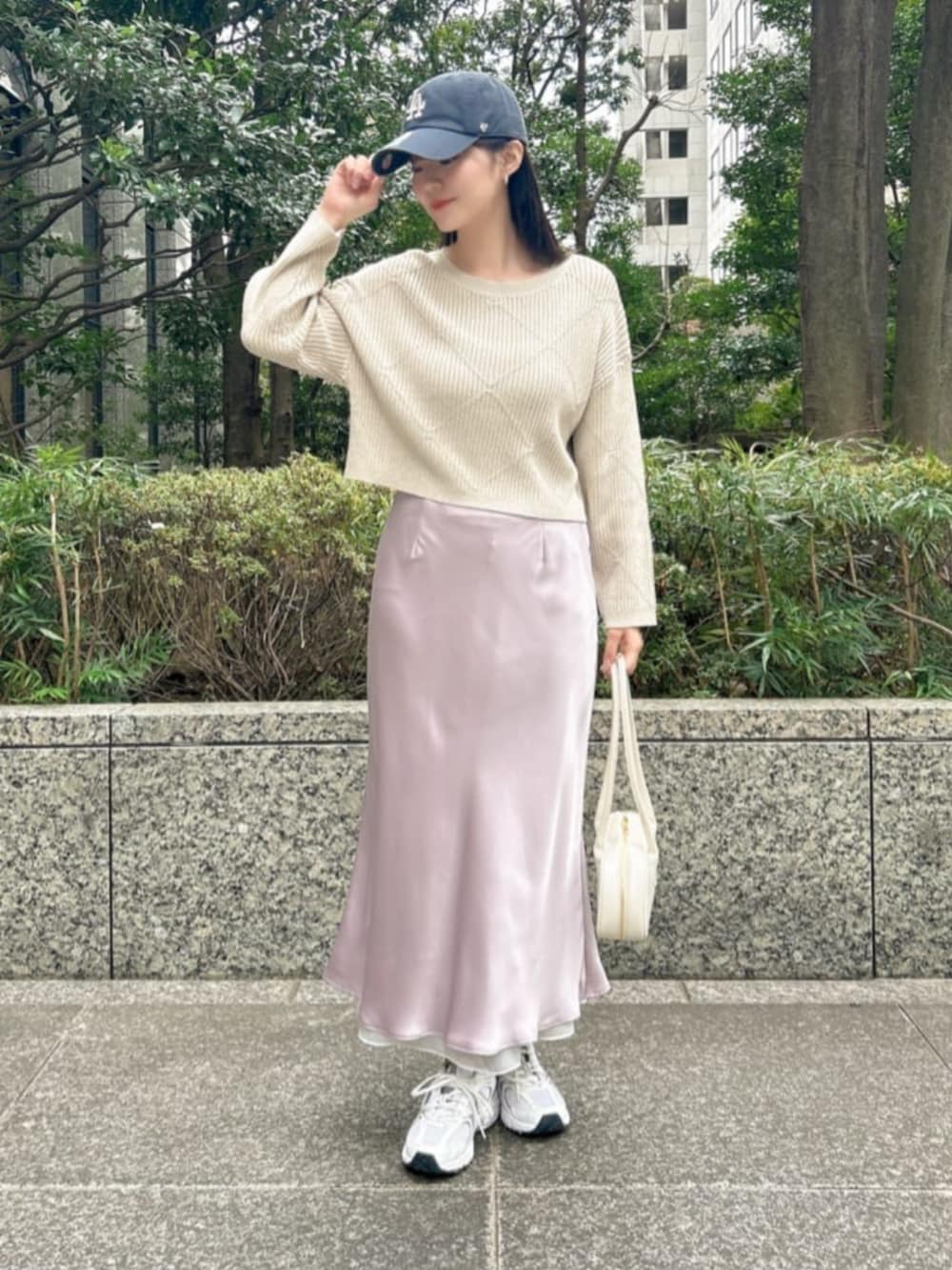 ベージュ系のニット/セーター、パープル系のスカートを着用したレディースの冬コーディネートの2枚目の写真