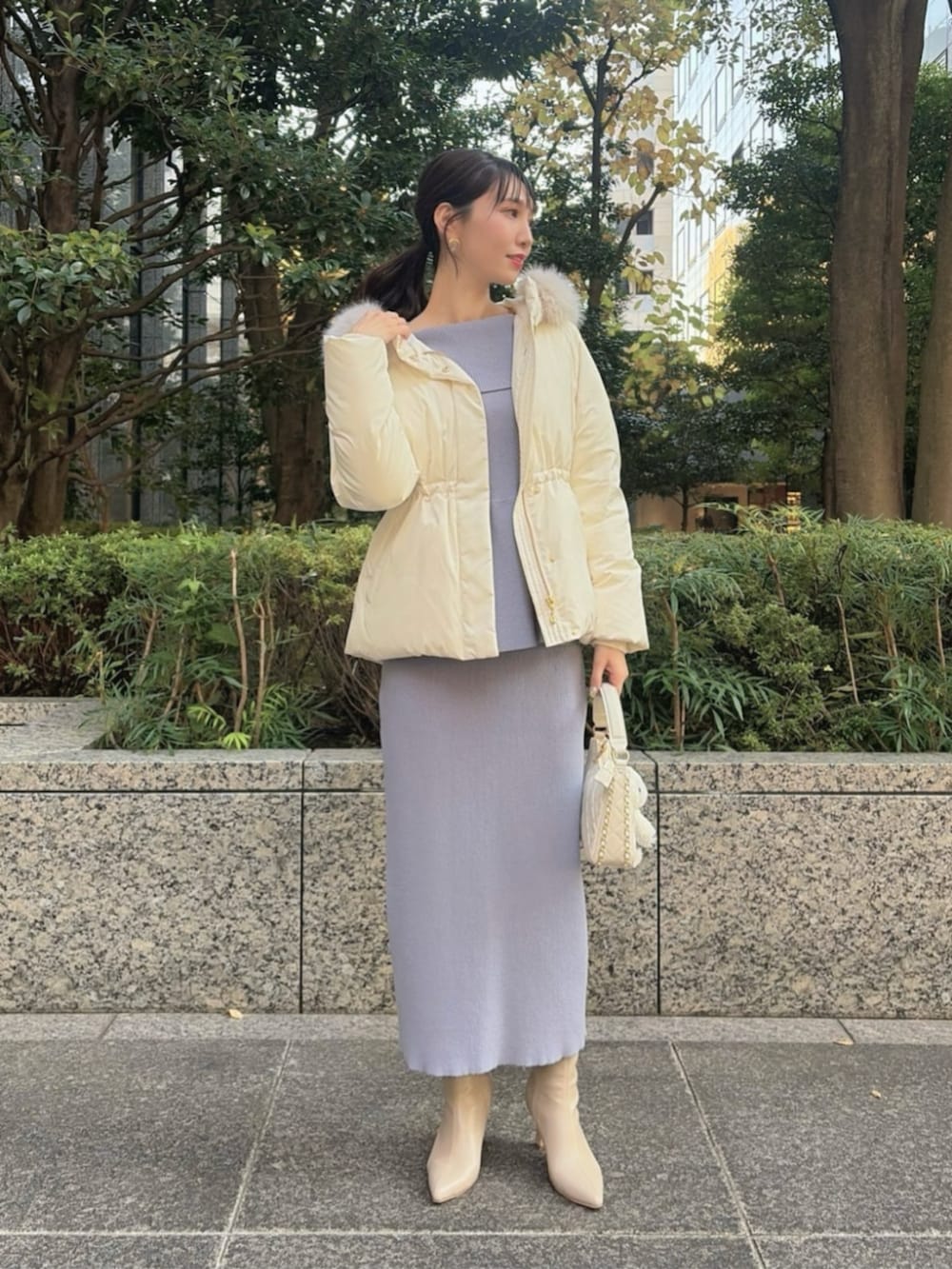 ホワイト系のショルダーバッグ、ホワイト系のダウンジャケット/コート、ブルー系のワンピースを着用したレディースの冬コーディネートの3枚目の写真