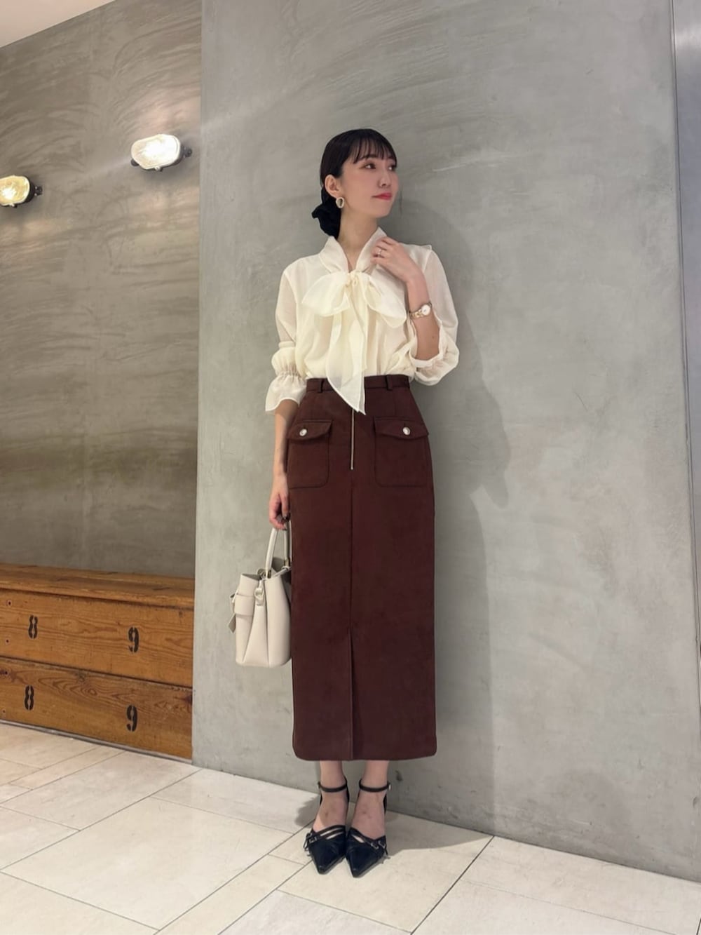 ブラック系のパンプス、ホワイト系のショルダーバッグ、ホワイト系のシャツ/ブラウスを着用したレディースの秋コーディネートの2枚目の写真