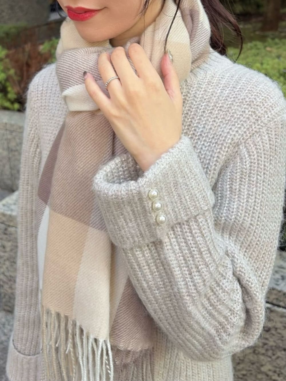 ブラウン系のブーツ、ホワイト系のショルダーバッグ、ベージュ系のワンピースを着用したレディースの冬コーディネートの3枚目の写真