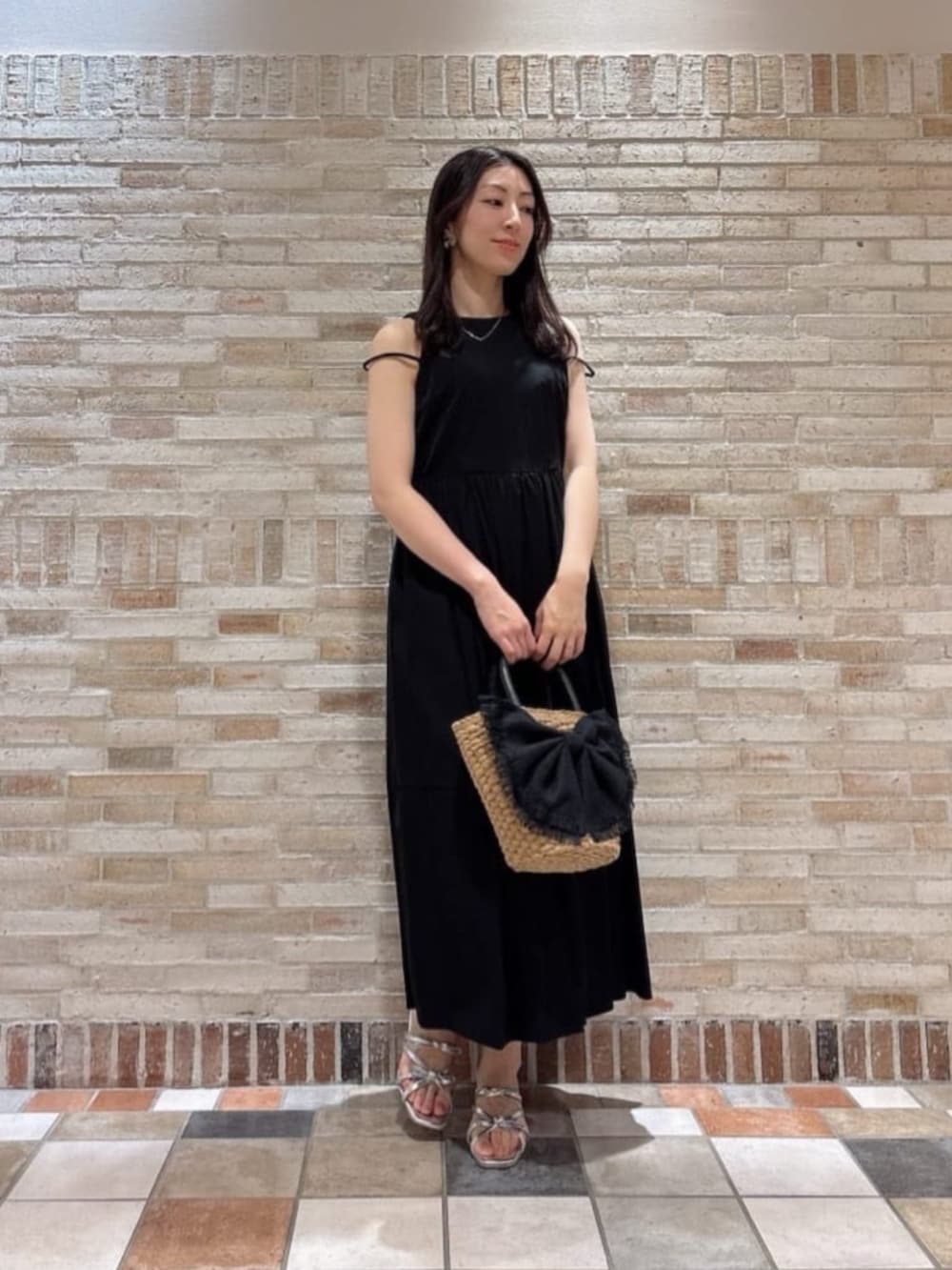 シルバー系のパンプス、ブラック系のワンピース、ブラック系のショルダーバッグを着用したレディースの夏コーディネートの3枚目の写真