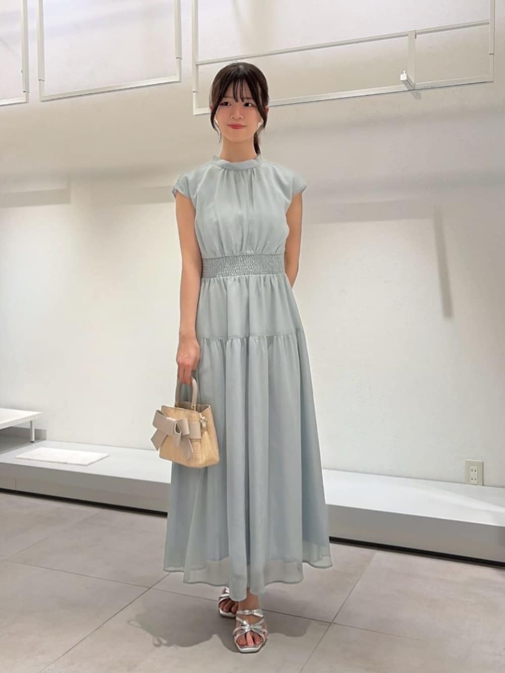 シルバー系のパンプス、ホワイト系のショルダーバッグ、ホワイト系のカーディガン/ボレロを着用したレディースの夏コーディネートの2枚目の写真