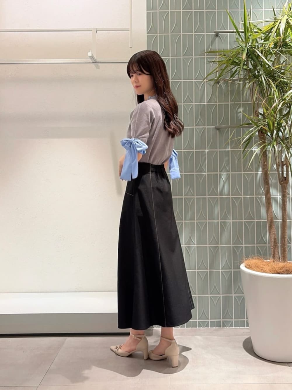 ベージュ系のパンプス、グレー系のニット/セーター、ブラック系のスカートを着用したレディースの秋コーディネートの2枚目の写真