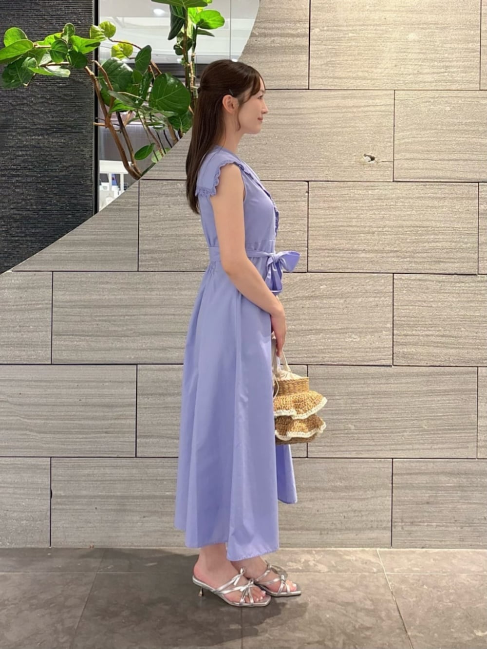 シルバー系のパンプス、ベージュ系のショルダーバッグ、ブルー系のワンピースを着用したレディースの夏コーディネートの2枚目の写真