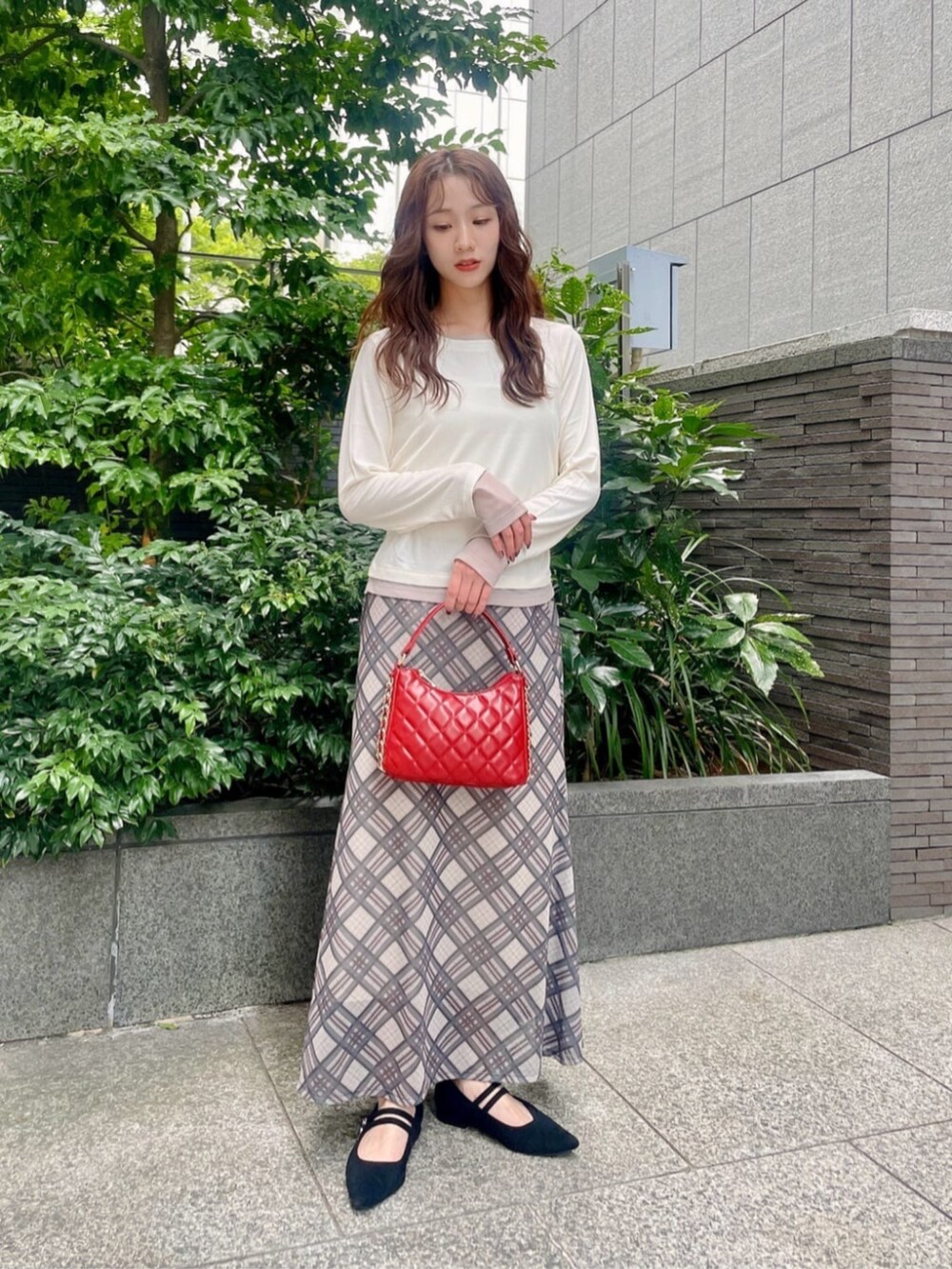 ブラック系のパンプス、ホワイト系のTシャツ/カットソー、ベージュ系のスカートを着用したレディースの秋コーディネートの2枚目の写真