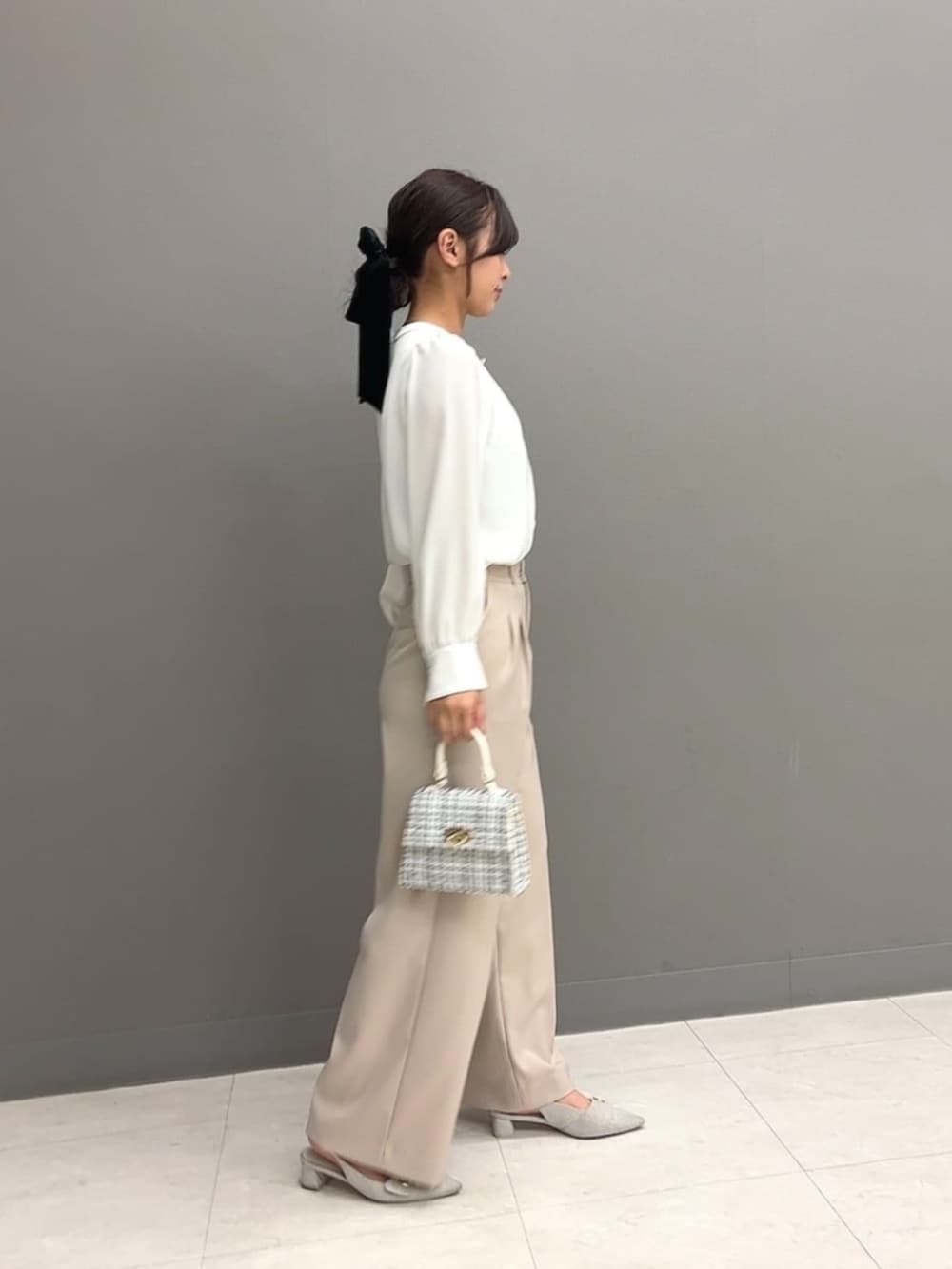 ホワイト系のショルダーバッグ、ホワイト系のシャツ/ブラウス、ベージュ系のその他パンツを着用したレディースの冬コーディネートの2枚目の写真
