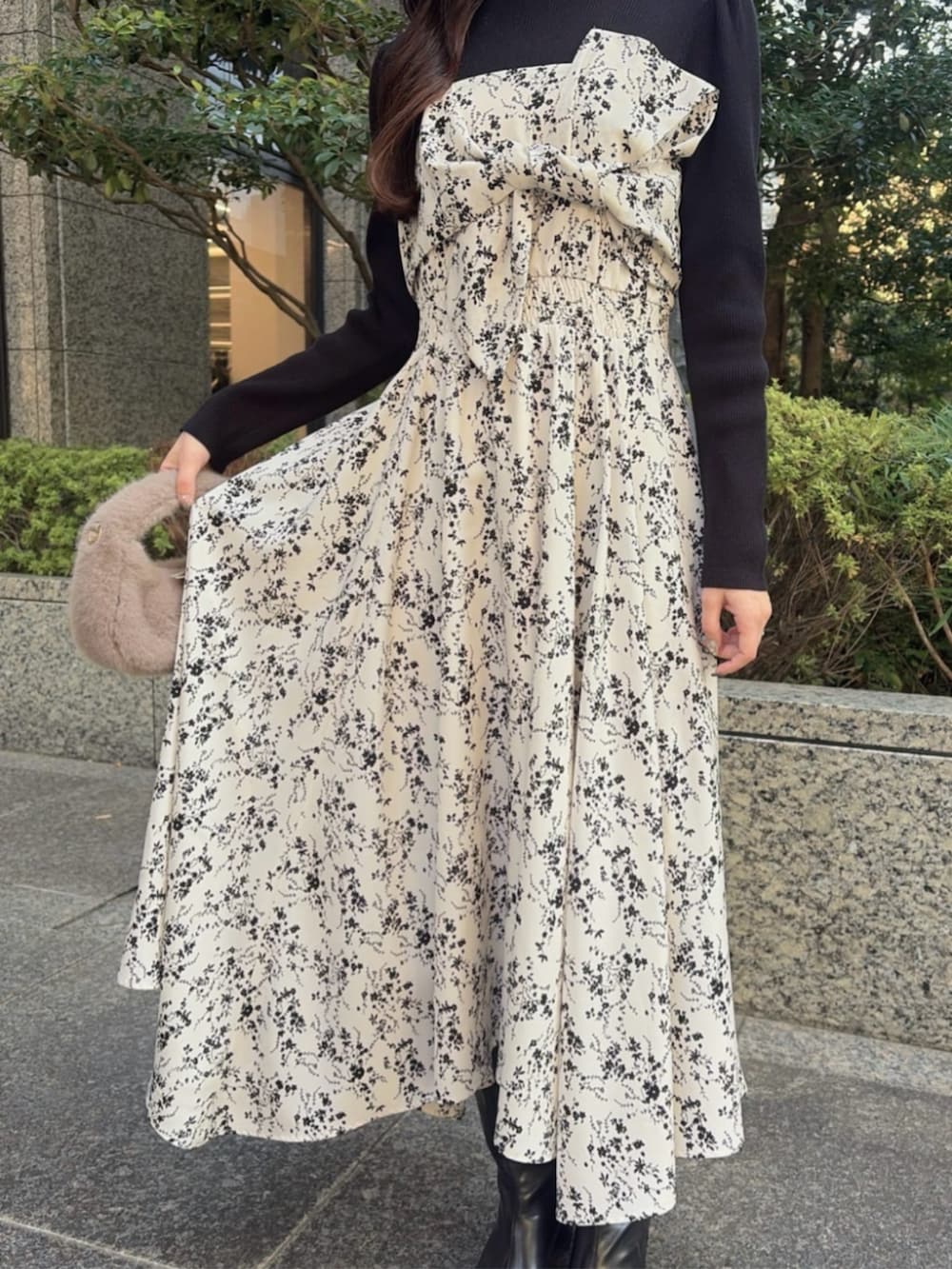 ブラウン系のハンドバッグ、ブラック系のブーツ、ベージュ系のワンピースを着用したレディースの冬コーディネートの3枚目の写真