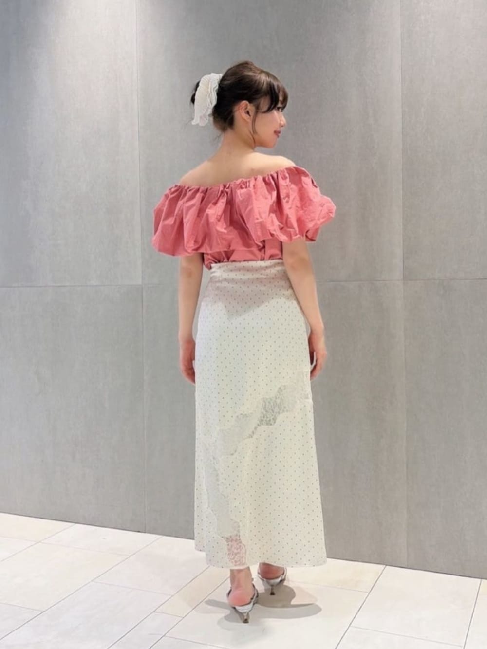 シルバー系のパンプス、ホワイト系のスカート、ピンク系のシャツ/ブラウスを着用したレディースの夏コーディネートの3枚目の写真