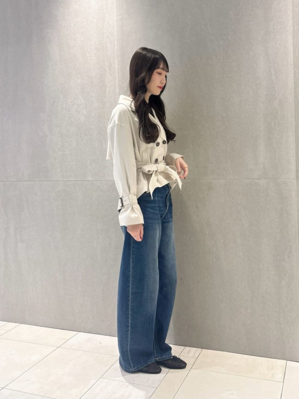 ホワイト系のトレンチコート、ブルー系のデニムパンツ、ブラック系のシャツ/ブラウスを着用したレディースの春コーディネートの2枚目の写真