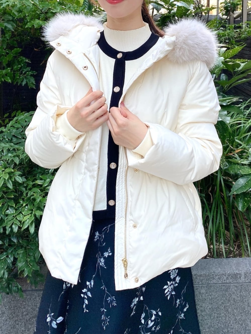 ホワイト系のダウンジャケット/コート、ブラック系のスカート、ホワイト系のアンサンブルを着用したレディースの秋コーディネートの3枚目の写真