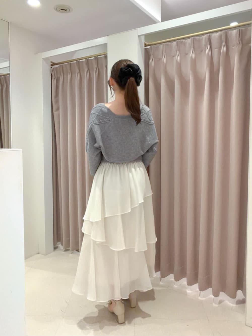ベージュ系のパンプス、ホワイト系のボストンバッグ、ホワイト系のスカートを着用したレディースの秋コーディネートの3枚目の写真