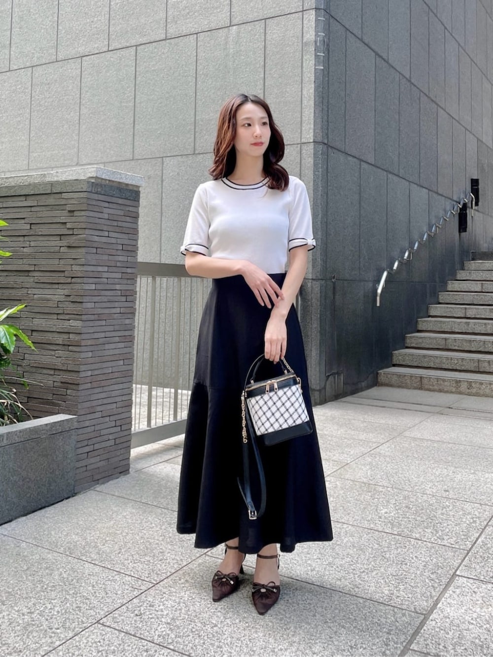 ホワイト系のニット/セーター、ブラック系のスカートを着用したレディースの春コーディネートの3枚目の写真