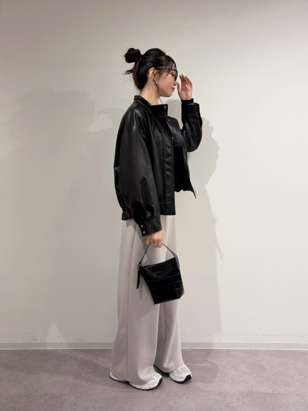 ブラック系のブルゾン、ブルー系のニット/セーター、グレー系のスウェットパンツを着用したレディースの冬コーディネートの3枚目の写真