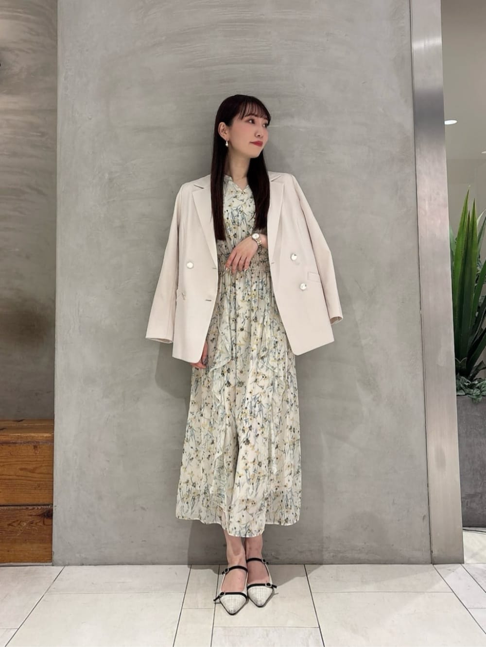 イエロー系のワンピース、ホワイト系のテーラードジャケットを着用したレディースの春コーディネートの2枚目の写真